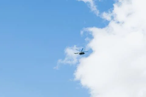 Helicopter on a background of blue sky with clouds Stock Photos