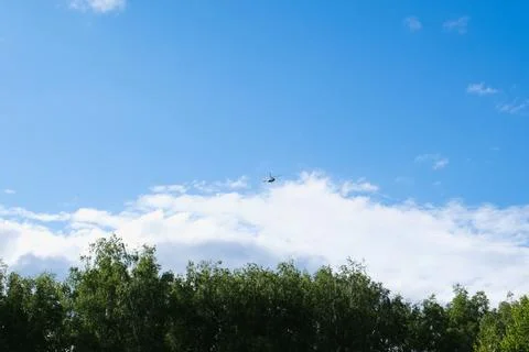 Helicopter on a background of blue sky with clouds Stock Photos