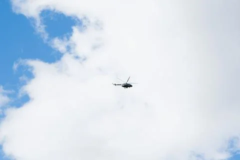 Helicopter on a background of blue sky with clouds Stock Photos
