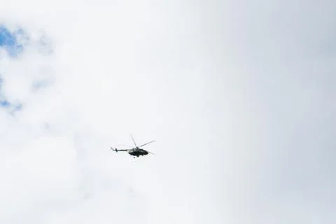 Helicopter on a background of blue sky with clouds Stock Photos