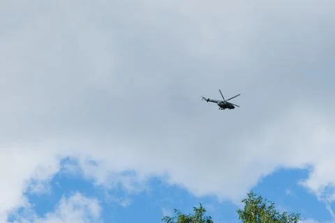 Helicopter on a background of blue sky with clouds Stock Photos
