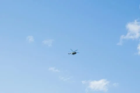 Helicopter on a background of blue sky with clouds Stock Photos