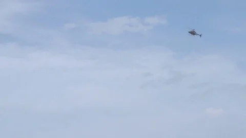 Helicopter in the blue sky among clouds Stock Footage 70407623