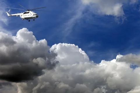 Helicopter in blue sky with clouds Stock Photos