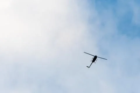 The helicopter on the blue sky with clouds Stock Photos