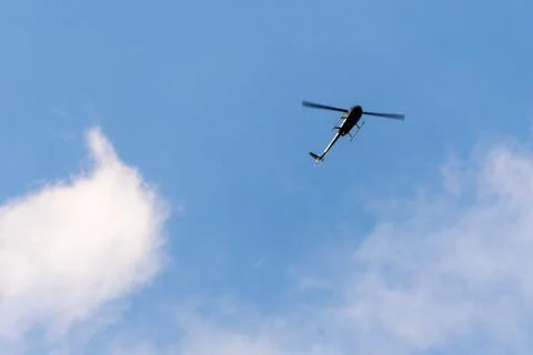 The helicopter on the blue sky with clouds Stock Photos