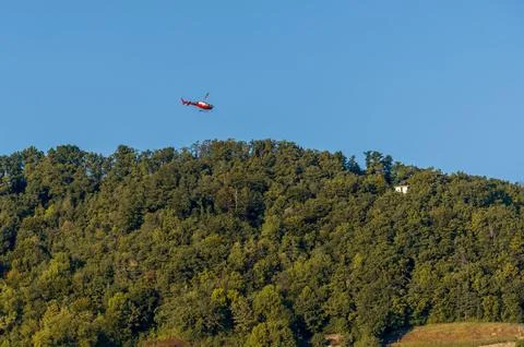 Helicopter Carrying External Load Above Lavaux Forest in Switzerland Foto stock