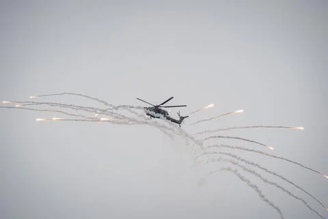 Helicopter Deploying Flares in Dramatic Maneuver Stock Photos