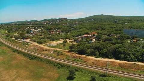 Helicopter ( drone, quadcopter ) flies over a settlement and a railway Stock Footage 92201236