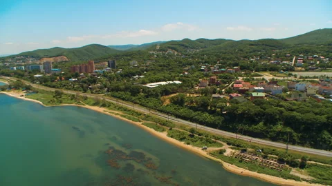 Helicopter ( drone, quadcopter ) flies over the settlement, the sea, the railway Stock Footage 92201341