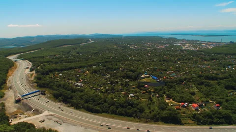 Helicopter ( drone, quadcopter ) flies over the settlement near the sea, road  Stock Footage 92201608