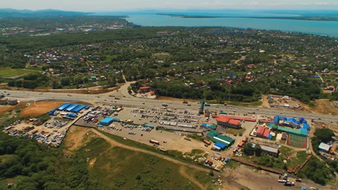 Helicopter ( drone, quadcopter ) flies over the city near the sea, houses, road  Stock Footage 92201625