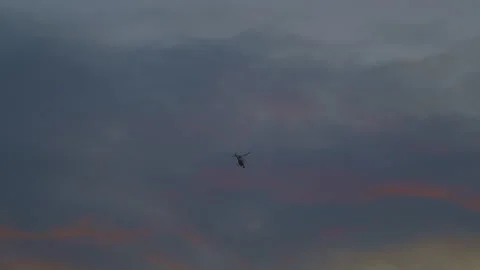 The helicopter flies against the background of the sunset sky Stock Footage 259443565