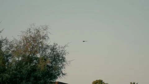 A helicopter flies high in the evening Stock Footage 220610613