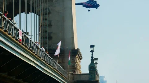 A helicopter flies over the Chain Bridge / Budapest at air and water parade Stock Footage 103166783