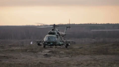 Helicopter in flight at sunset above war field Stock Footage 113357609