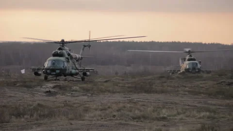 Helicopter in flight at sunset above war field Stock Footage 113357703