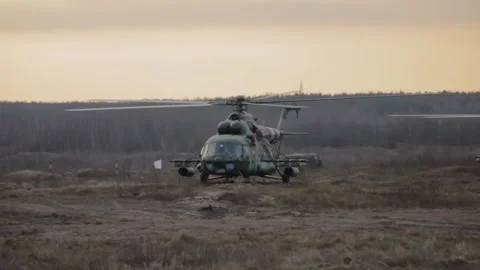 Helicopter in flight at sunset above war field Stock Footage 117692611