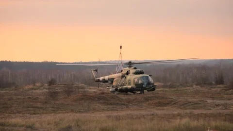 Helicopter in flight at sunset above war field Stock Footage 121672888