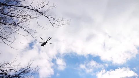 Helicopter fly across blue sky with white and purple clouds Stock Footage 79078993