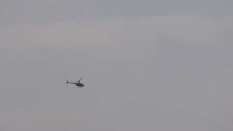 Helicopter flying in the background of the cloudy sky. Stock Footage 70400573
