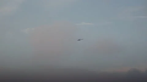 Helicopter flying in blue cloudy sky Stock Footage 166154598