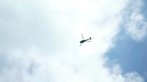Helicopter flying in the blue sky with clouds Stock Footage 130252642
