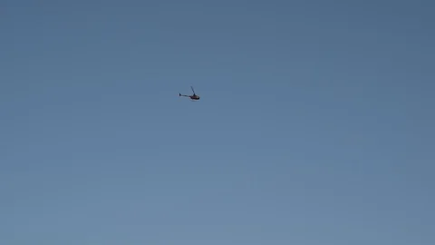 Helicopter flying in blue sky Stock Footage 88220873