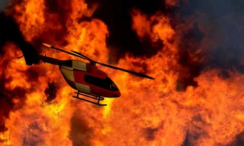 Helicopter flying by a bushfire Stock Photos