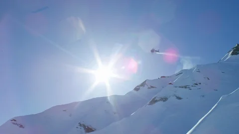 Helicopter flying fast down the mountain in Alaska on a bright sunny day Video stock 129129816