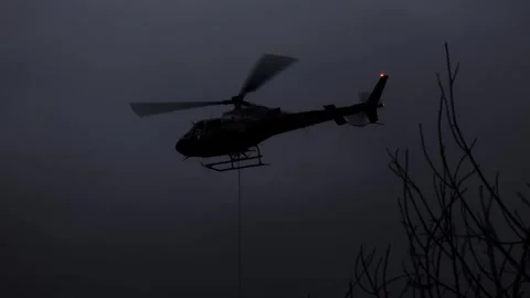 Helicopter Flying with a Hanging Cable and Tree Branch at Night in Switzerland Stock Footage 317345313