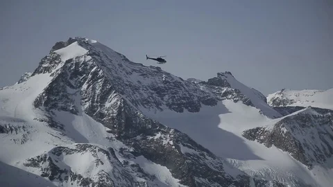 Helicopter flying high in the sky above the Alpine mountains Stock Footage 77146485