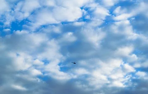 The helicopter is flying high in the sky backdrop of clouds Foto stock