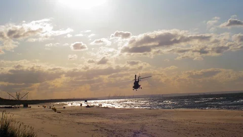 Helicopter Flying Low Over Sandy Sea Beach at Sunset Slow Motion Stock Footage 116032828
