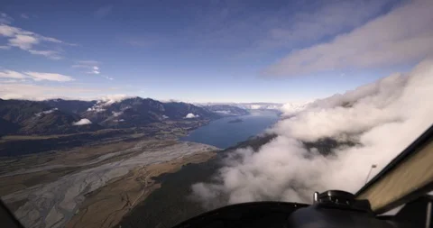 Helicopter flying over the clouds and rocky terrain in South Islands Stock Footage 93607287