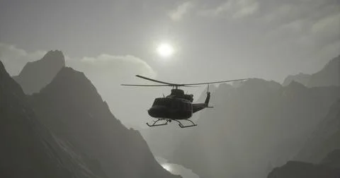 Helicopter flying over dramatic mountain landscape during sunset 스톡 일러스트