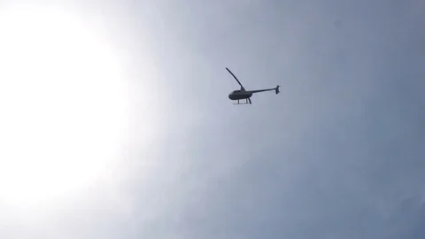 Helicopter flying over the earth on a background of clear sky Stock Footage 79173906