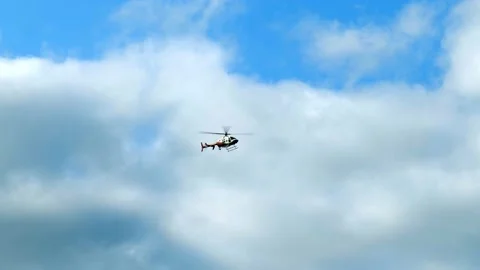 Helicopter flying over, with a mostly cloudy sky. Stock Footage 147458778