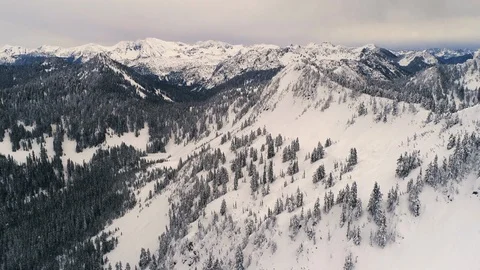 Helicopter Flying Over Mountain Ridge in Winter Snow Stock Footage