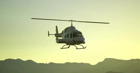 Helicopter flying over mountains during sunset in a clear sky Ilustração Stock