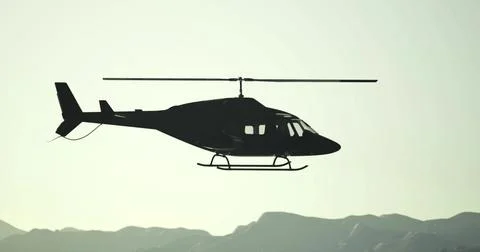 Helicopter flying over mountains at sunset with clear sky and silhouettes Ilustração Stock