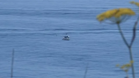 Helicopter Flying Over Open Water With Boats in The Background Video stock 152800534
