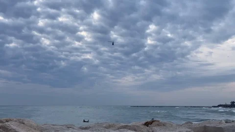 Helicopter flying over the sea. View from the ground Stock Footage 123851136