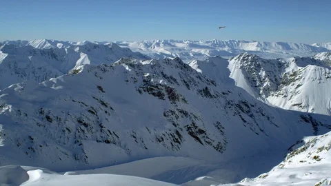 Helicopter flying over the snow covered mountains Stock Footage 116749459