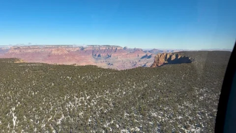 Helicopter Flying Over Snow-Covered Forest Near Grand Canyon Stock Footage 282385693