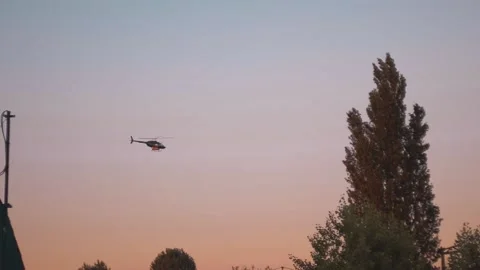 Helicopter flying over sunset Stock Footage 135584504