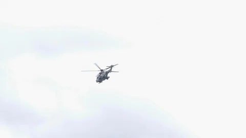 Helicopter flying in slow motion in the cloudy sky at the beach. 4K. 動画素材 107815841