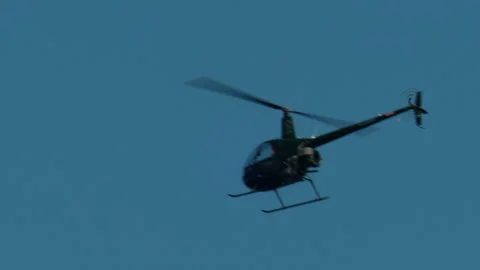 Helicopter flying solo through a clear blue sky, aircraft showcasing aviation Stock Footage 339797422