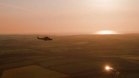Helicopter flying at sunset, air to air filming in flight Stock Footage 241925354