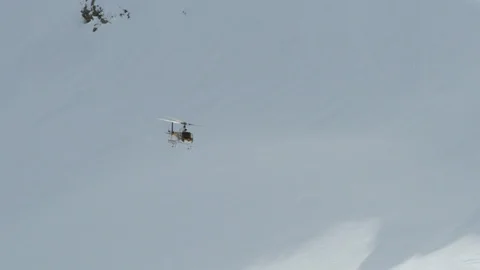 Helicopter flying through the valleys of snowy mountain Stock Footage 116788766